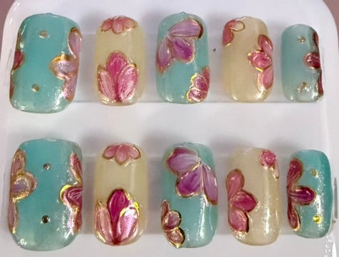 Light yellow and green short square nails with pink flower petals